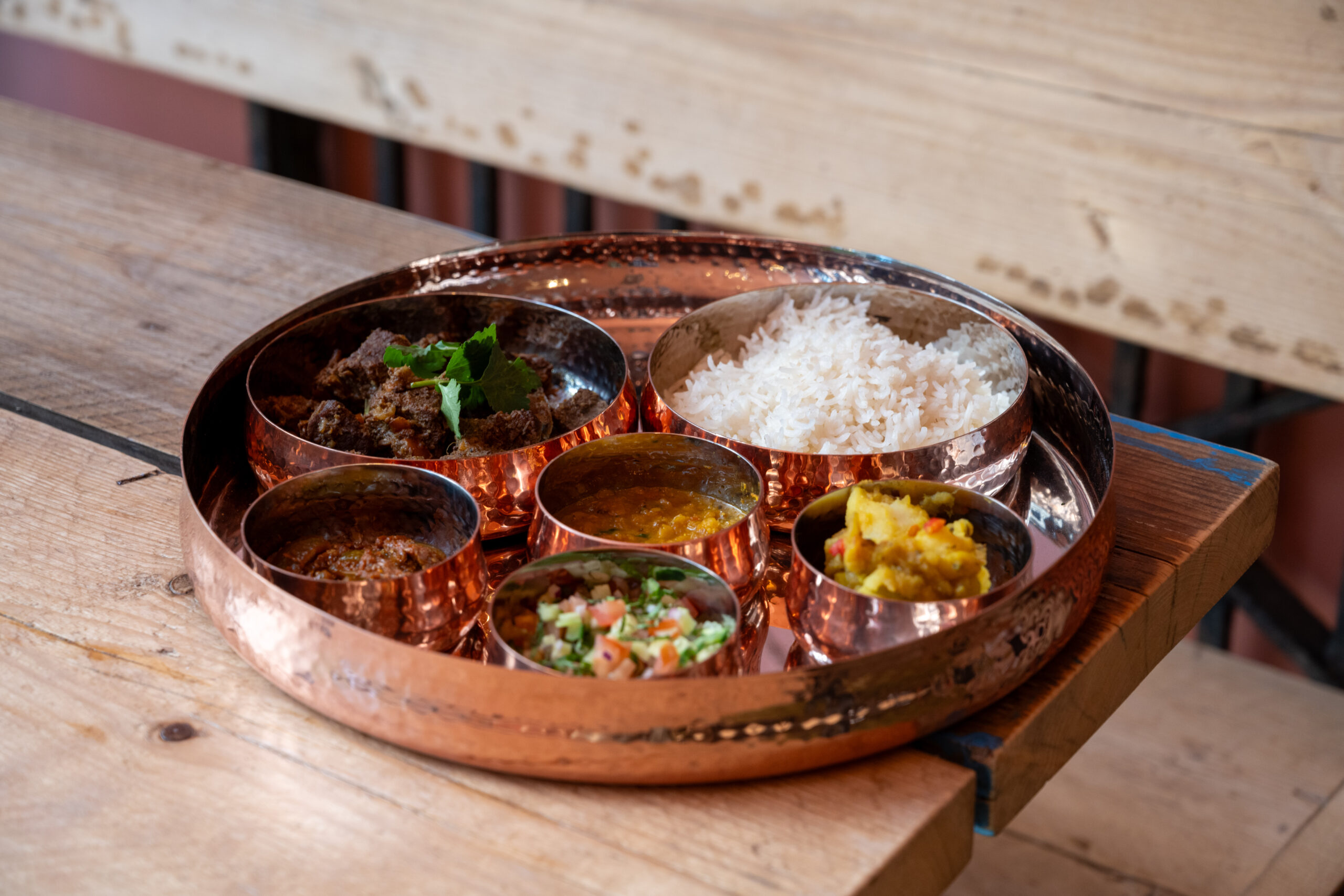 Traditional Indian thali with various curries and rice.