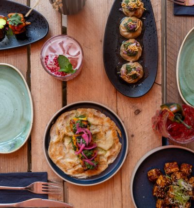 A beautifully arranged table with diverse colorful dishes and drinks.